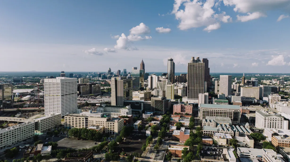 Aerial view of Atlanta skyline with skyscrapers under a blue sky with clouds