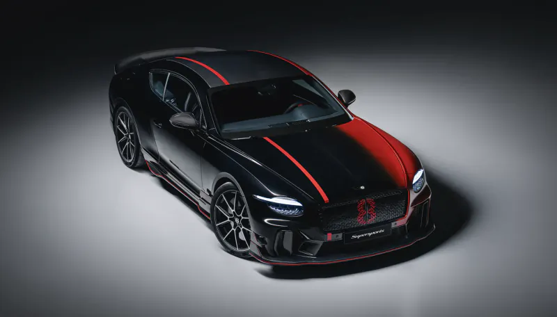 Black Jaguar Supersport coupe with red racing stripes and red '8' grille badge in studio lighting