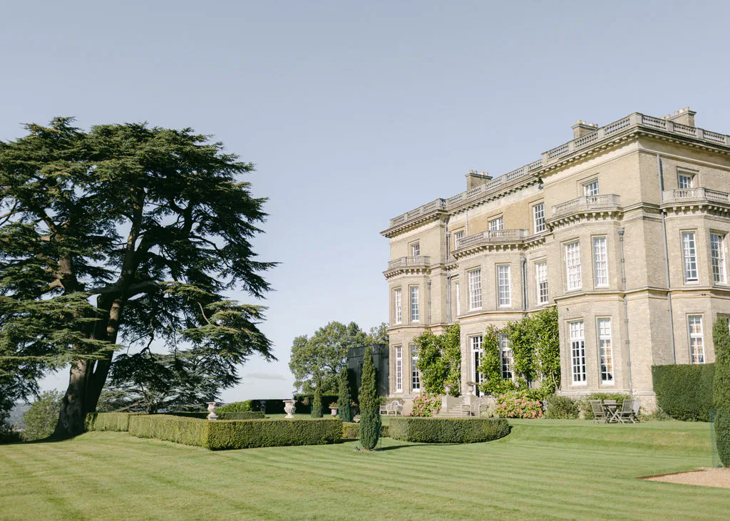 Hedsor House Buckinghamshire: grand stone mansion with ivy-covered facade and manicured gardens under clear sky