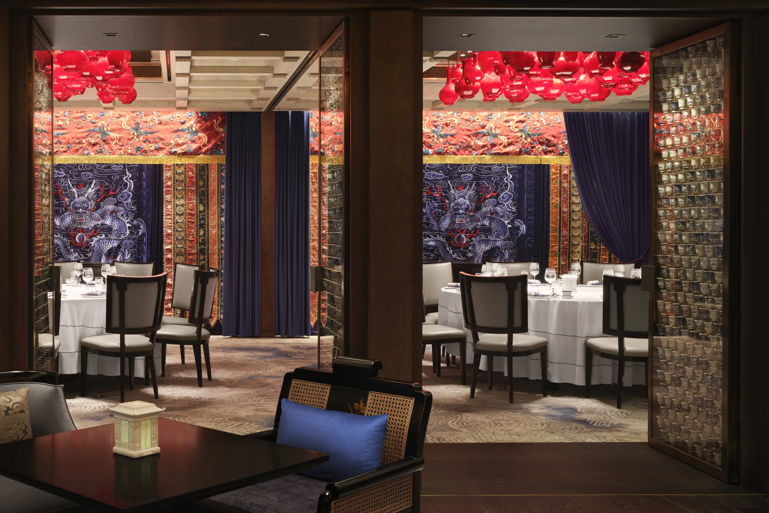 Elegant Canton Blue restaurant interior with ornate red dragon murals, red lanterns, and white-clothed dining tables