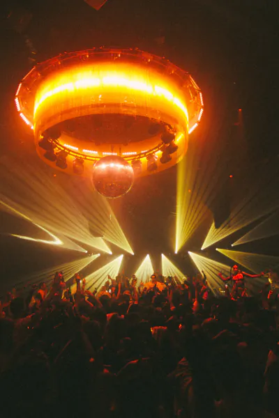 Crowd dancing under glowing circular stage light and disco ball at Chinois Ibiza nightclub