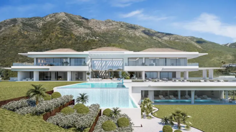 Modern luxury villa with infinity pool overlooking green mountains under blue sky