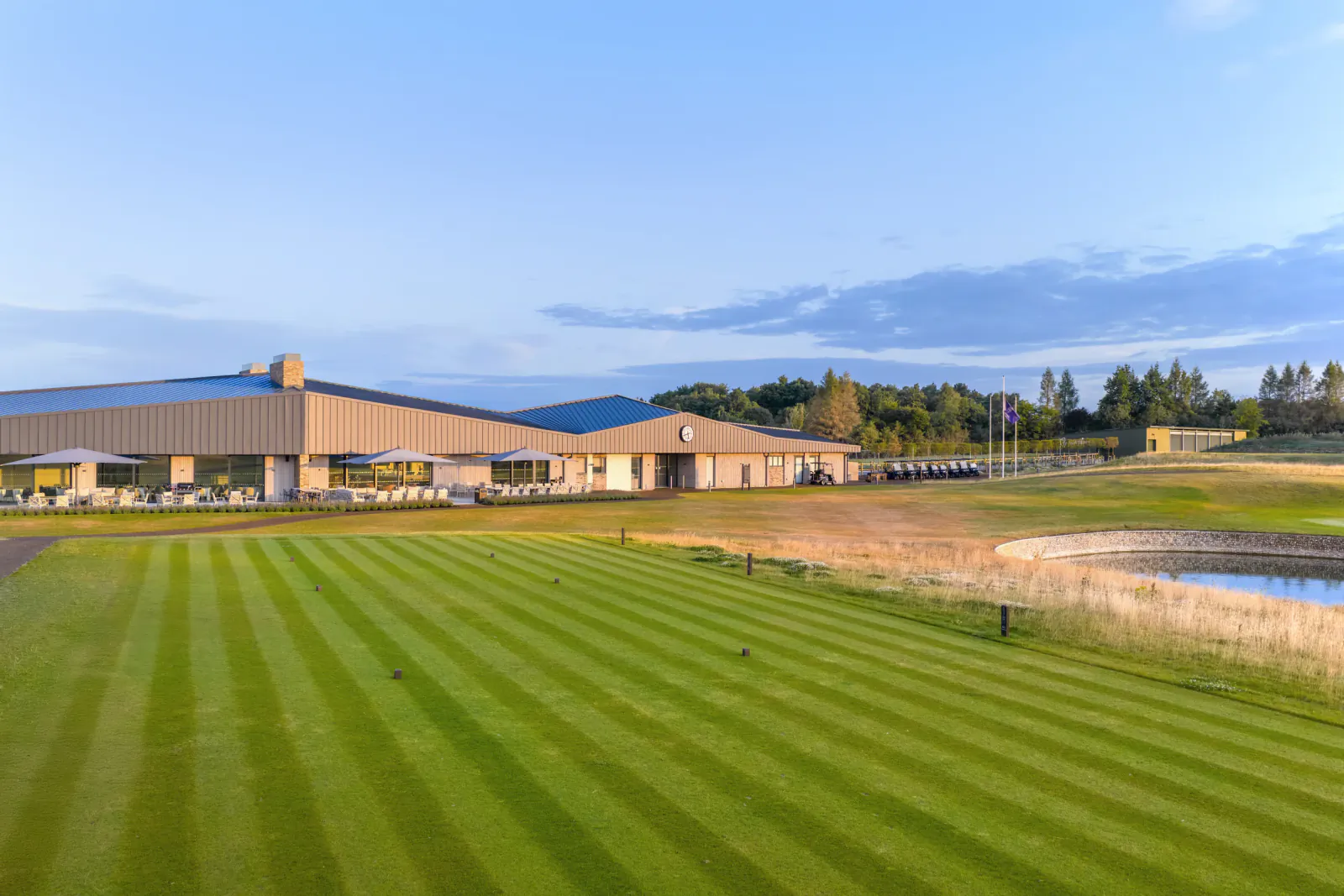 Modern clubhouse overlooking striped fairway at Basingstoke Golf Club