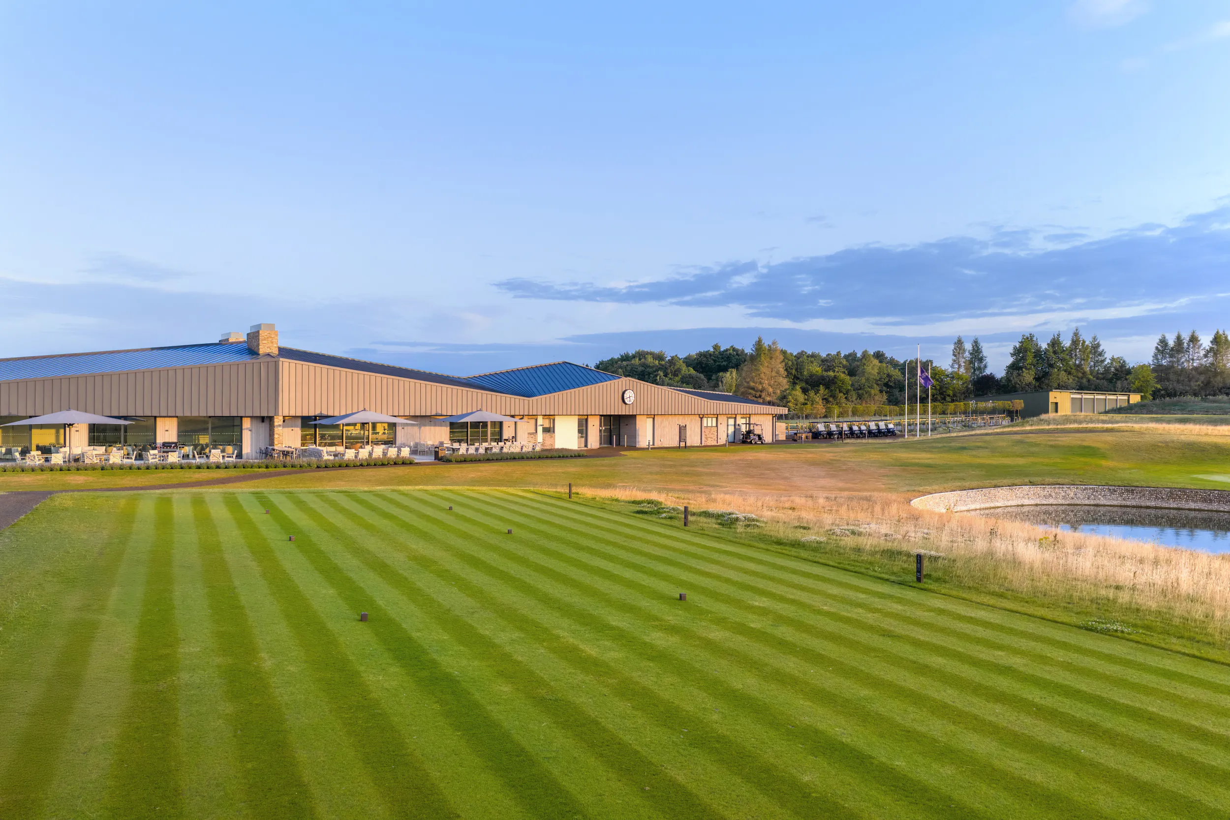 Modern clubhouse overlooking striped fairway at Basingstoke Golf Club