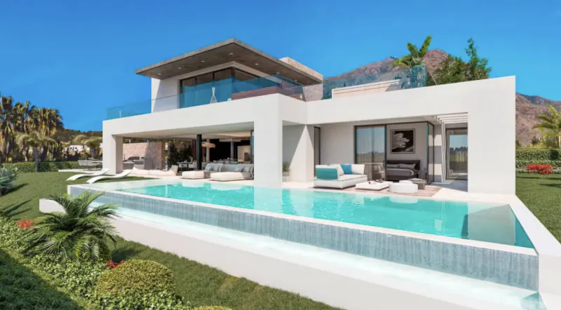 Modern white luxury villa with infinity pool overlooking mountains under clear blue sky
