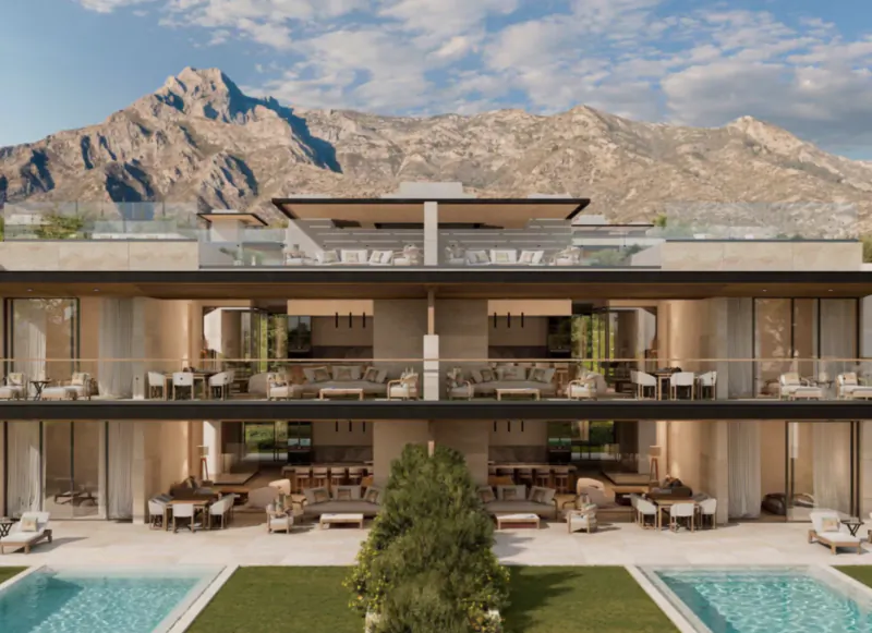 Modern luxury villa with multiple terraces overlooking a pool, lawn, and mountain backdrop in Marbella