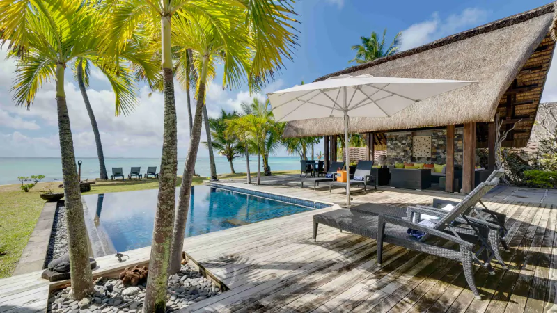 Luxury beachfront villa with infinity pool, palm trees, and ocean view in Mauritius