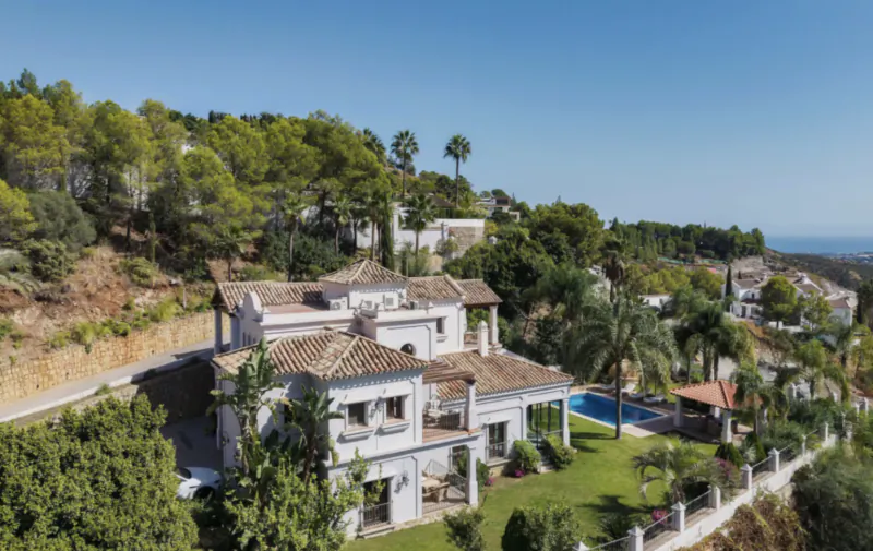 Luxury white villa with terracotta roof, pool, and sea views in Marbella hillside