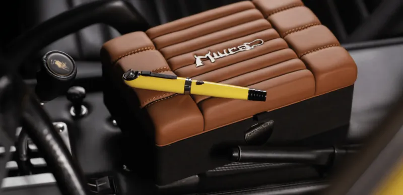 Yellow Montegrappa pen on brown quilted Lamborghini armrest with logo